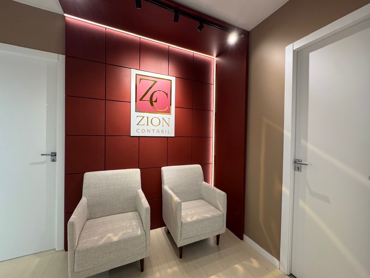 Recepção da Zion Contábil, parede bordô com a marca ZC